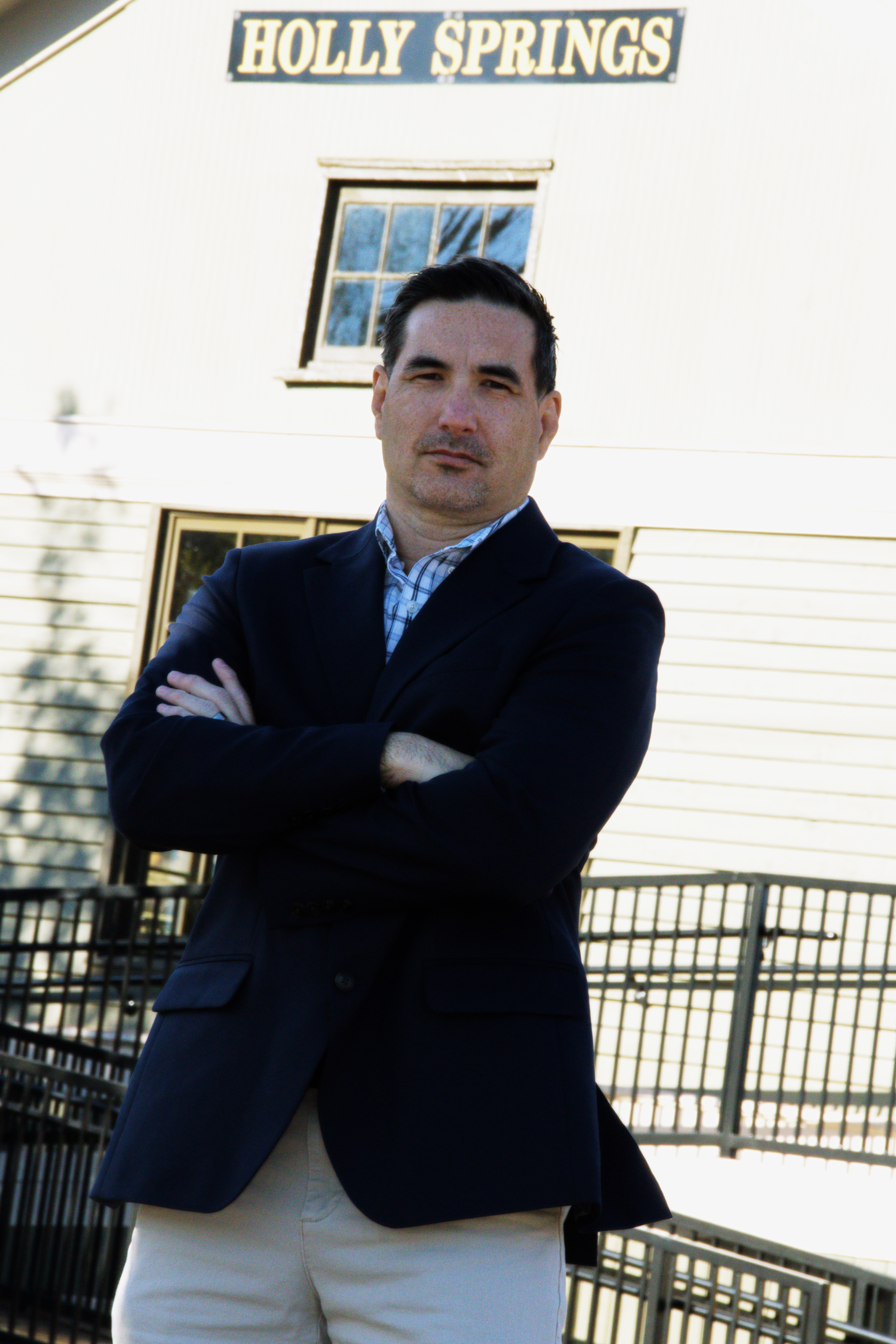 Campaign representative standing with arms crossed in Holly Springs